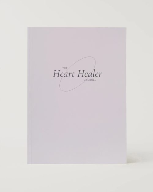 A minimalist journal titled "The Heart Healer Journal" on a soft lavender background. The elegant script conveys a soothing and reflective tone.
